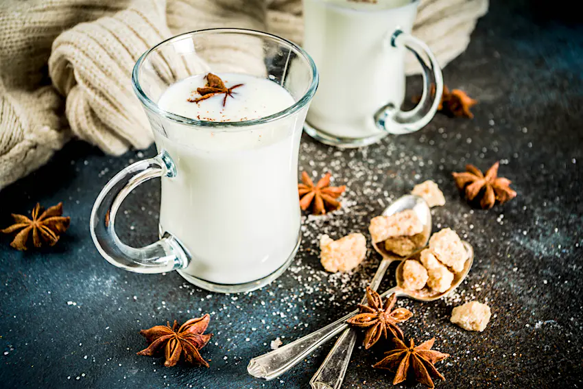 Dutch hot dairy drink Anijsmelk with milk, sugar and aniseed, dark blue rusty background copy space