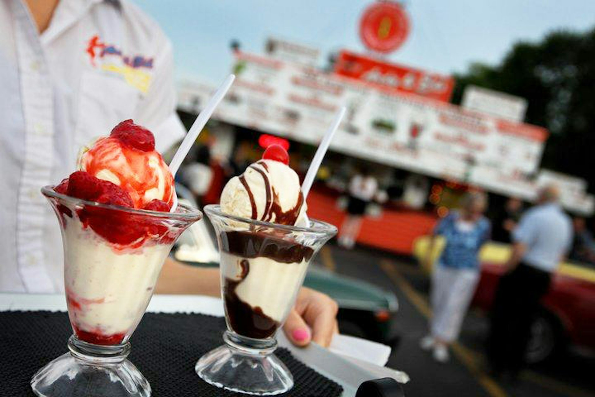 Close up of a pair of sundaes being held on a tray