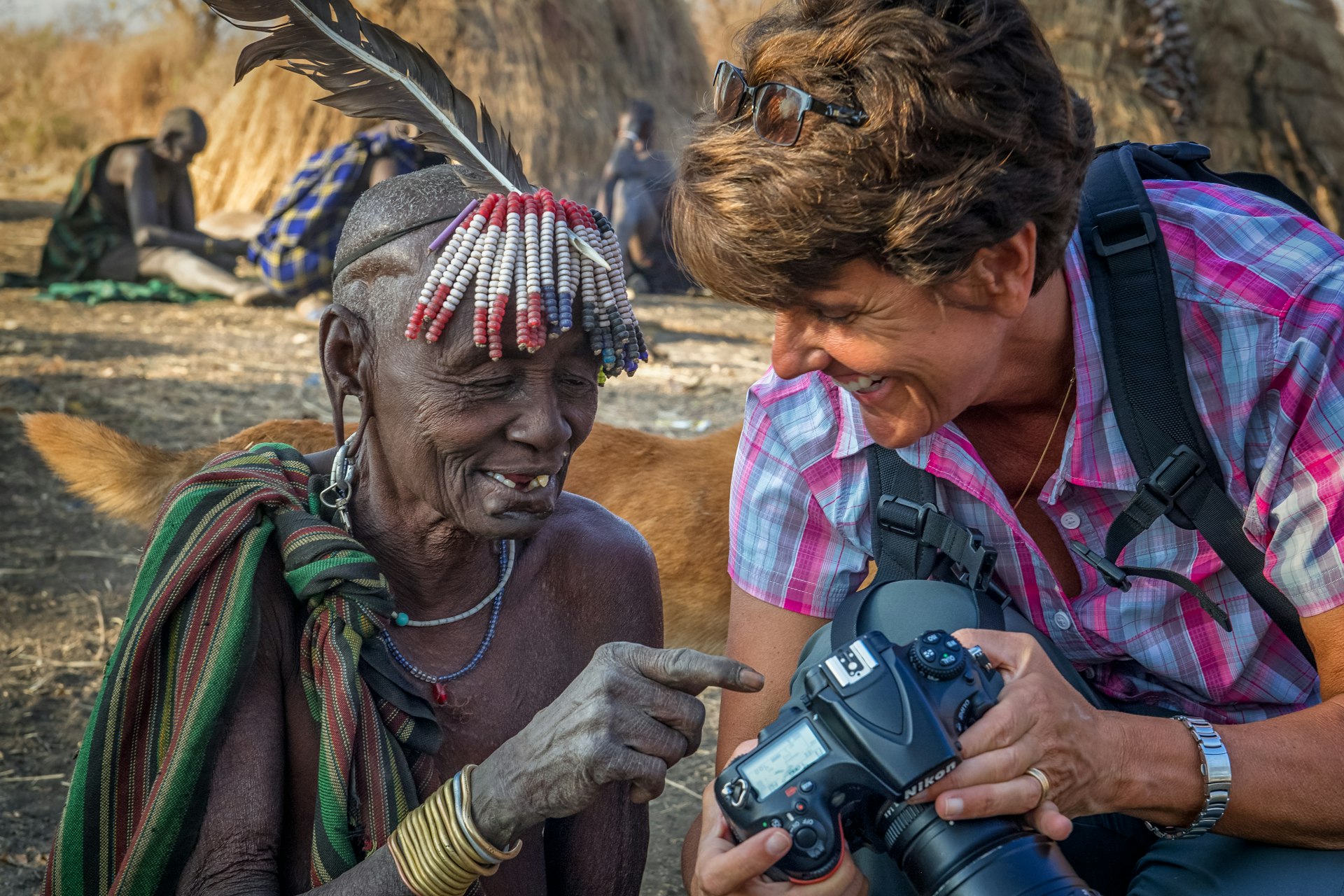 The photographer shows her camera to a tribal elder