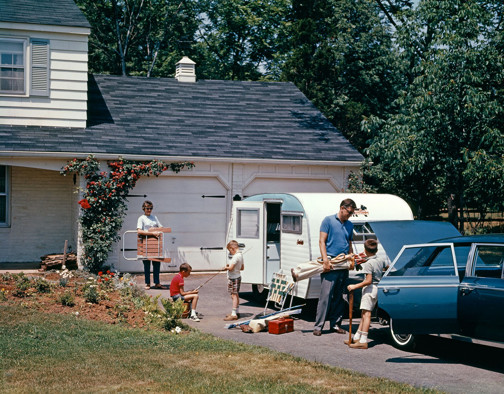 1960s FAMILY FATHER MOTHER SON DAUGHTER LOADING CAR AND TRAILER FOR VACATION SUMMER OUTDOOR