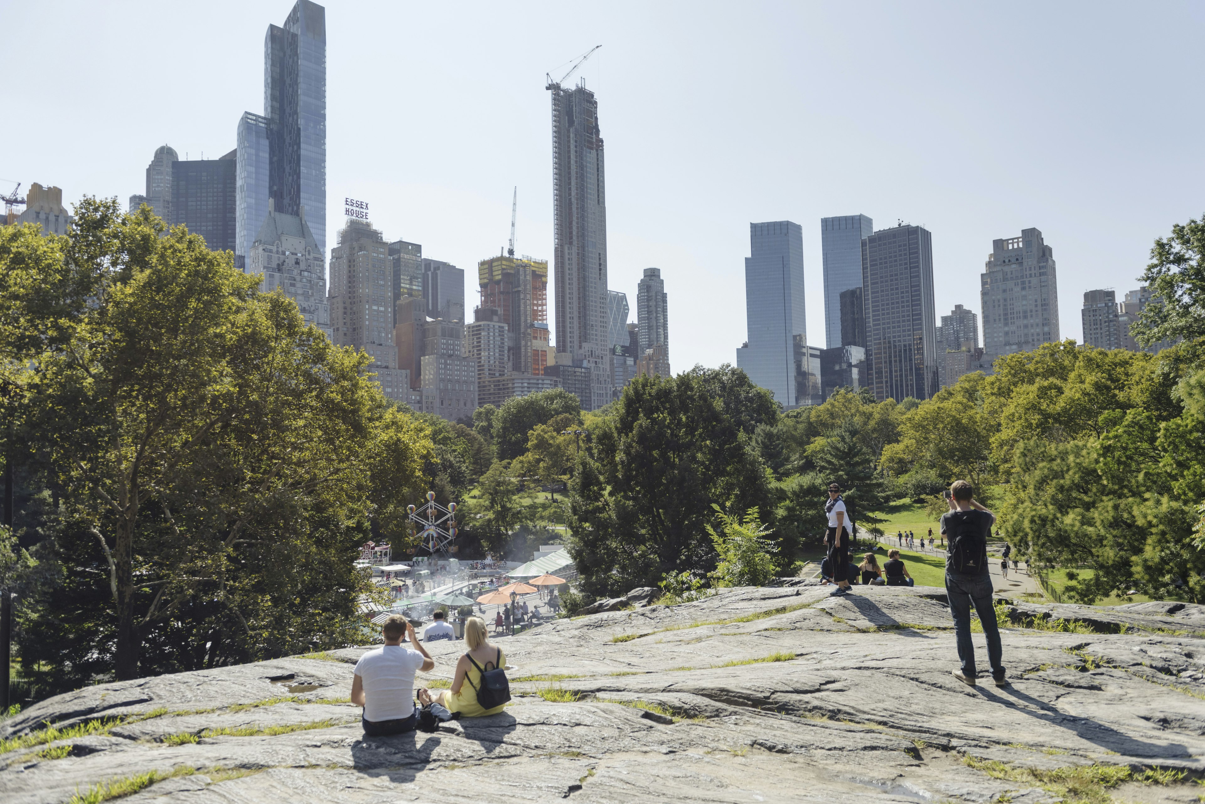 People relax on a rocky section of Central Park.