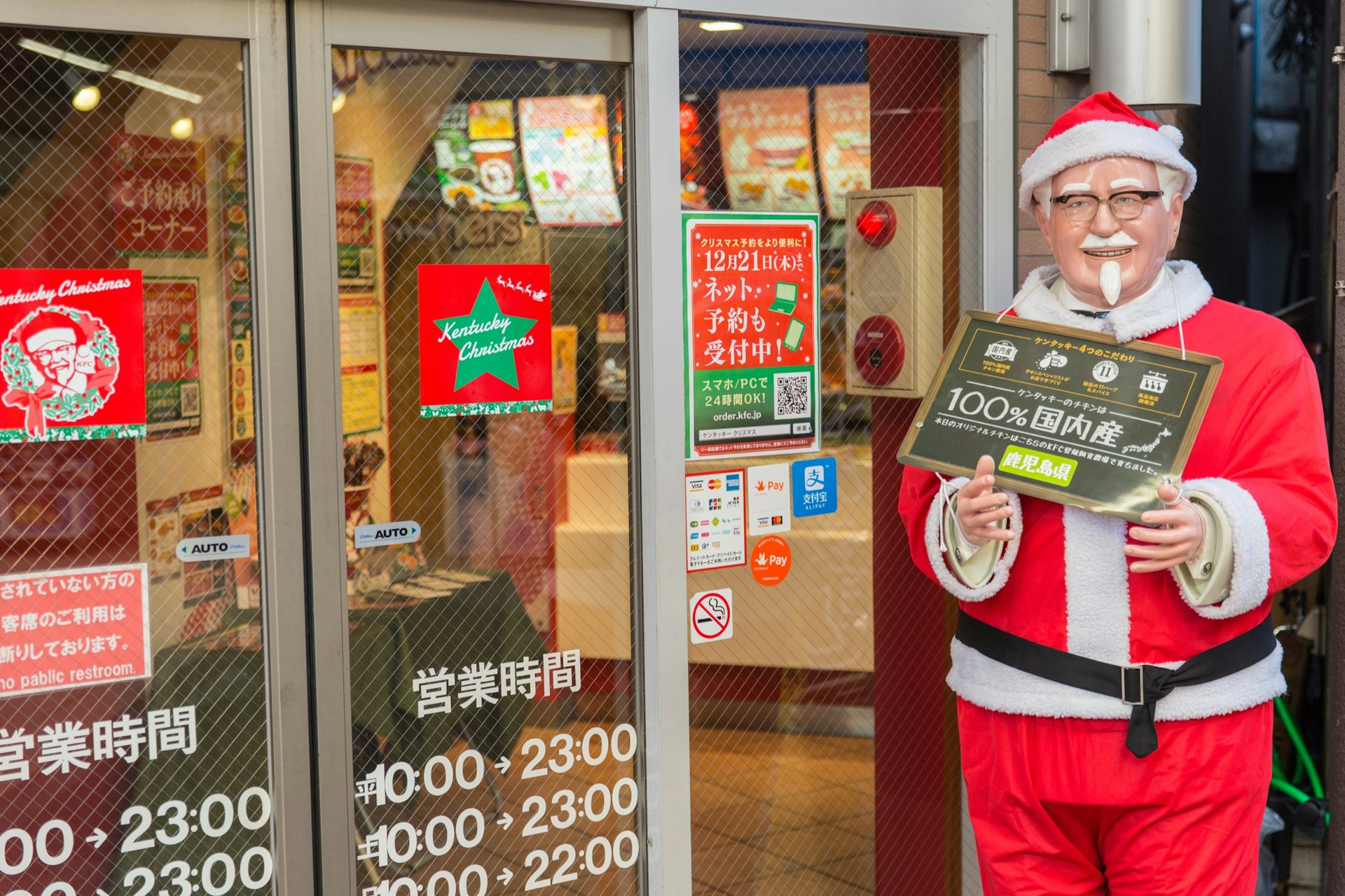 En staty av Kentucky Fried Chicken-maskot överste Sanders sitter utanför en butiksfront i Japan. 