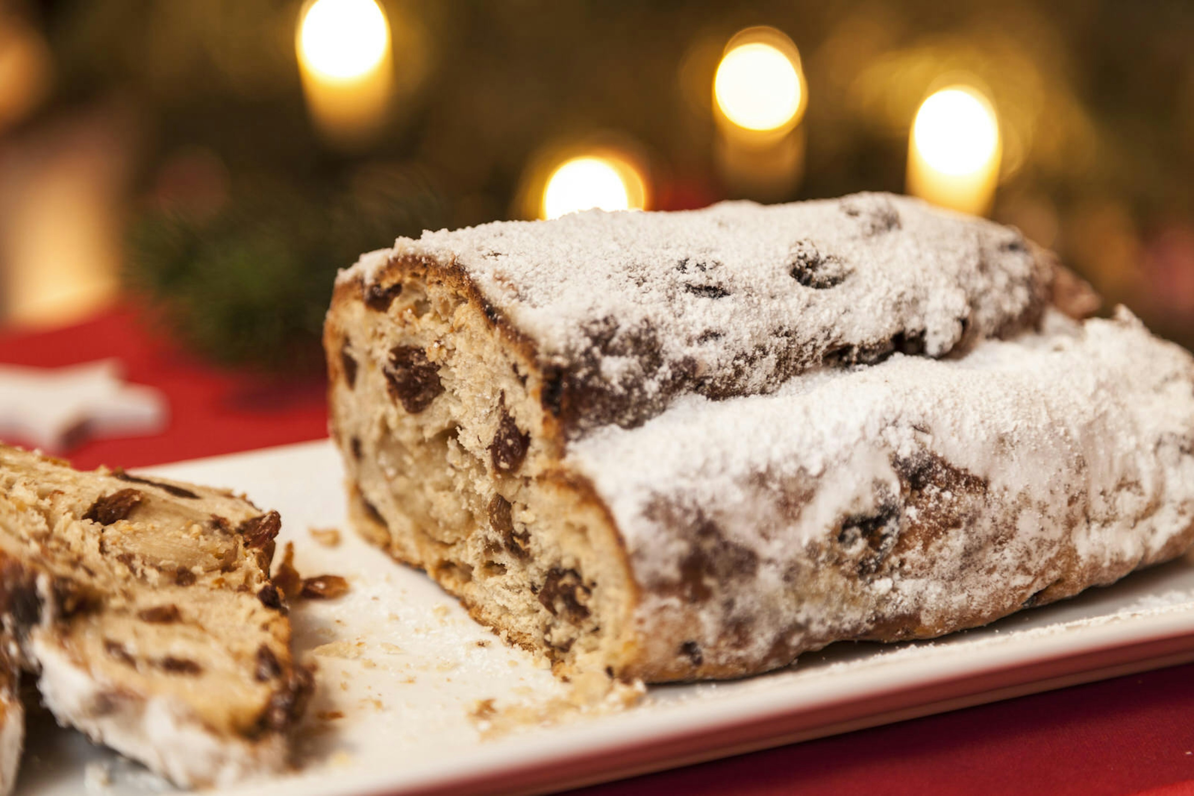 Closeup of powdered sugar topped, stollen dessert on a white plate