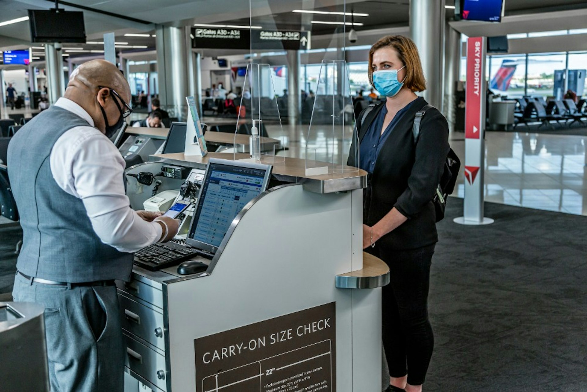 An attendant and passenger at the Delta check in desk
