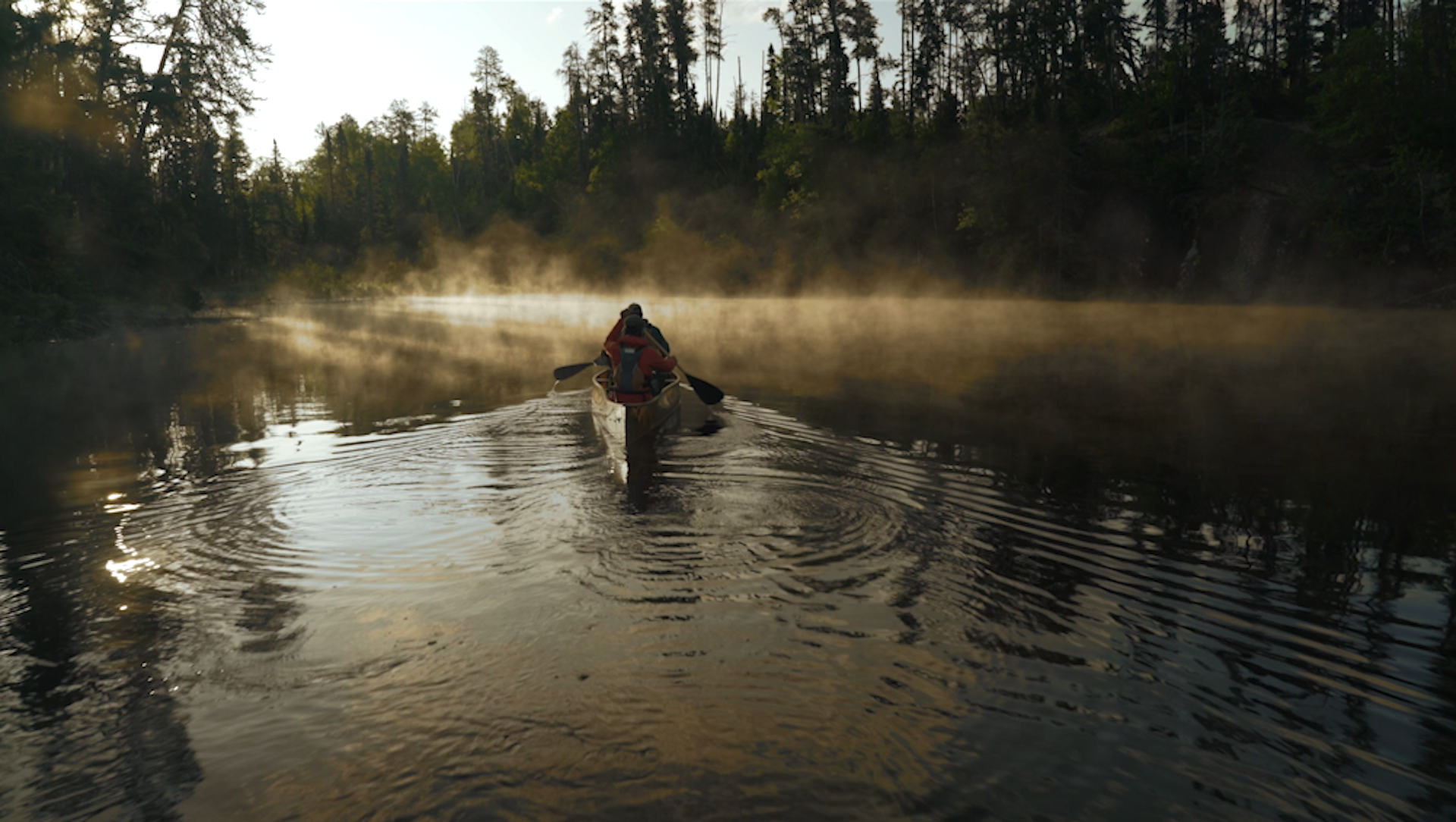 A person in a canoe in the middle of a river - a still from the film Public Trust