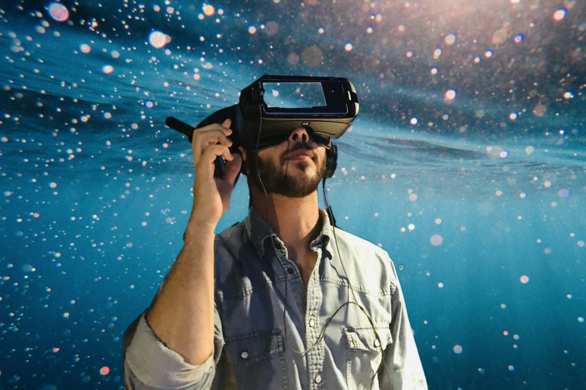 A man wearing VR glasses in a room full of stars