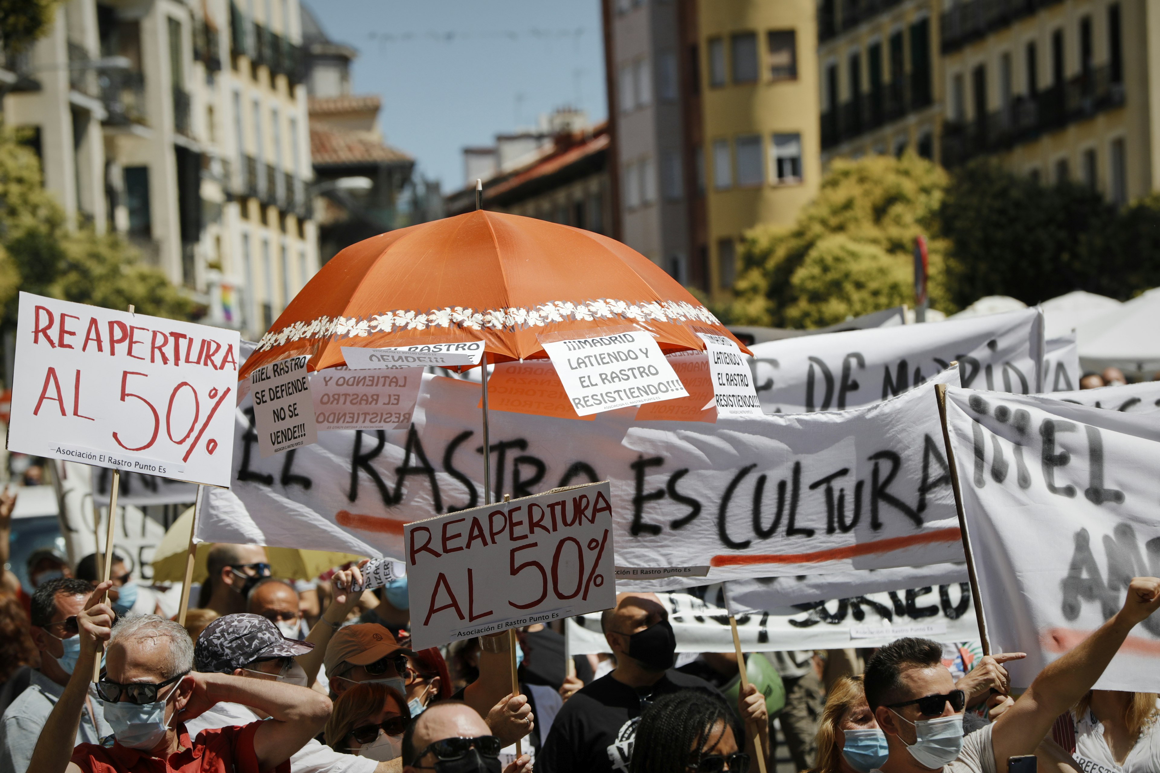 A crowd of people with posters and banners gather to protest