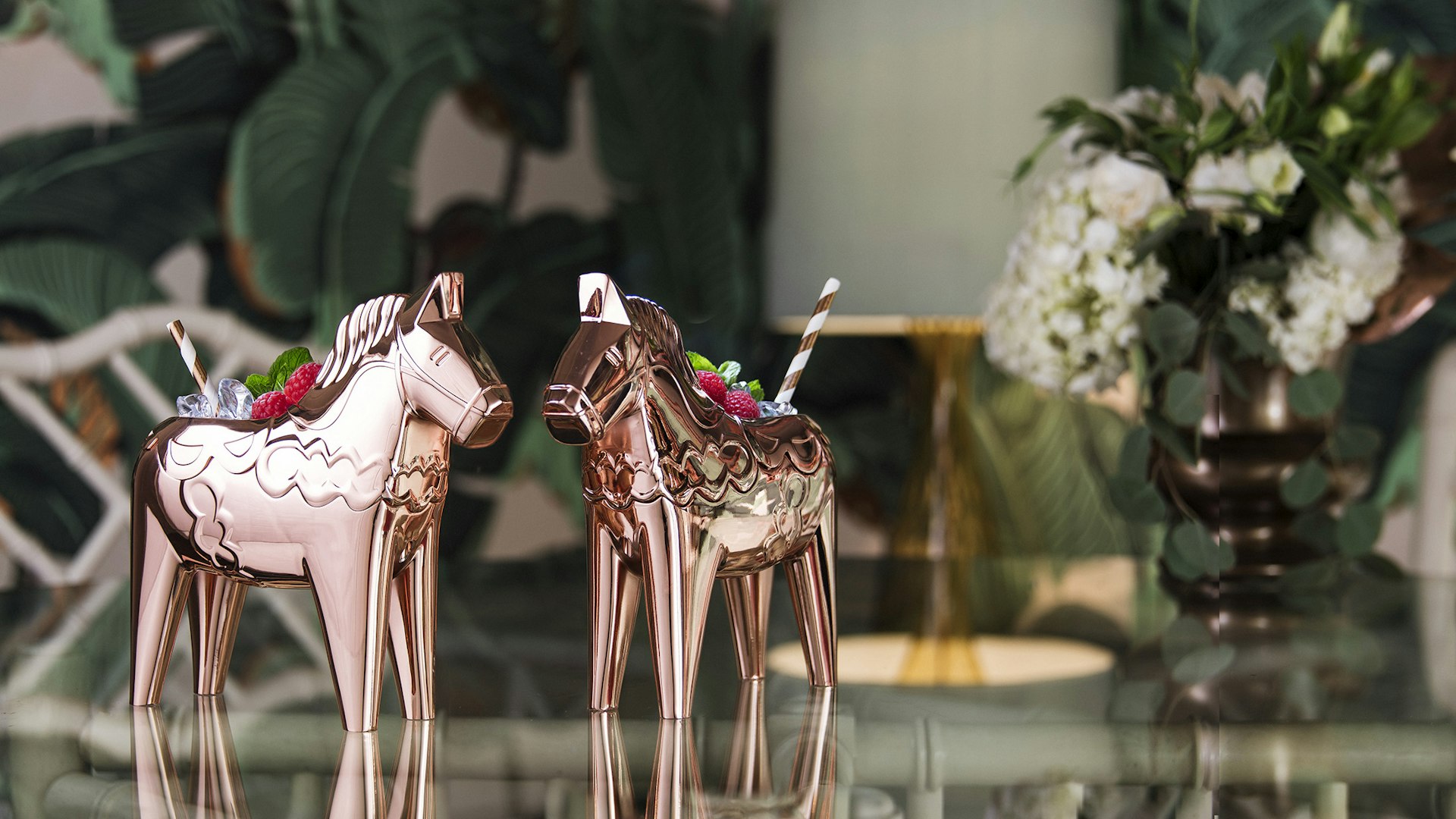 A pair of Absolut Elyx's copper Dala horse drinking cups