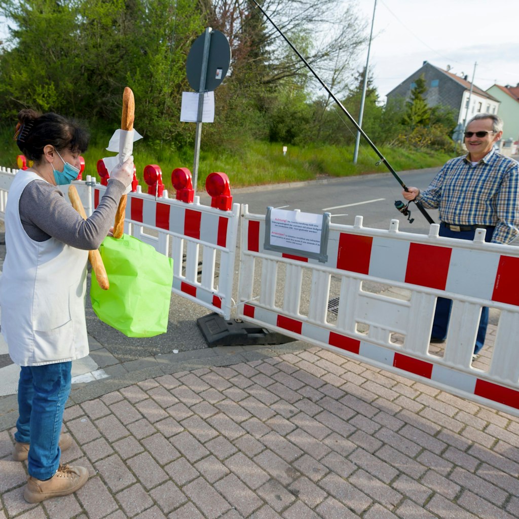 Hartmut Fey, a German citizen of Lauterbach, gets his French baguettes at the German-French border using his fisher rod to avoid a penalty of 250 on April 18, 2020 in Carling, eastern France, on the 33rd day of a lockdown in France aimed at curbing the spread of the COVID-19 infection caused by the novel coronavirus. (Photo by JEAN-CHRISTOPHE VERHAEGEN / AFP) (Photo by JEAN-CHRISTOPHE VERHAEGEN/AFP via Getty Images)
