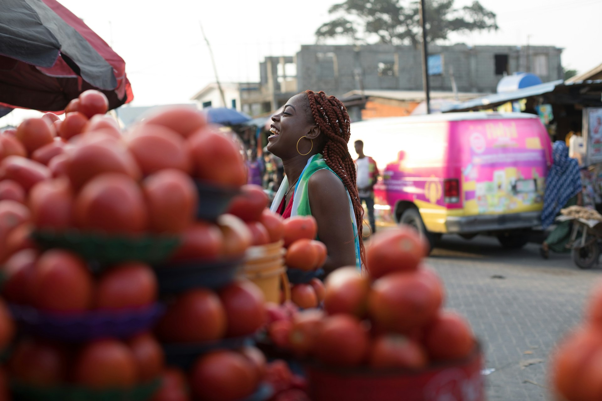 A young woman looks at the vegetables to buy at a market stall