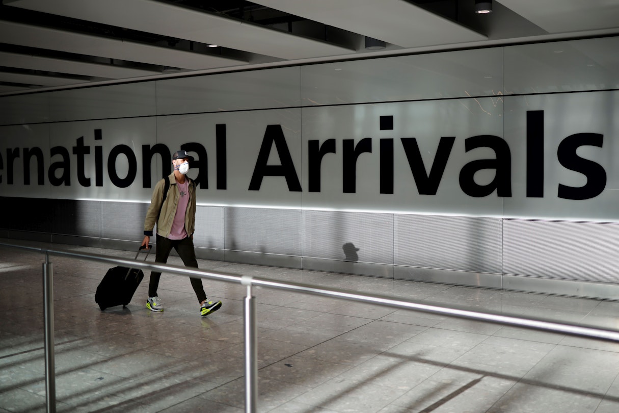 A passenger wearing a face mask as a precaution against the novel coronavirus arrives at Heathrow airport, west London, on May 22, 2020. - Travellers arriving in Britain will face 14 days in quarantine from next month to prevent a second coronavirus outbreak, the government announced on Friday, warning that anyone breaking the rules faced a fine or prosecution. (Photo by Tolga Akmen / AFP) (Photo by TOLGA AKMEN/AFP via Getty Images)