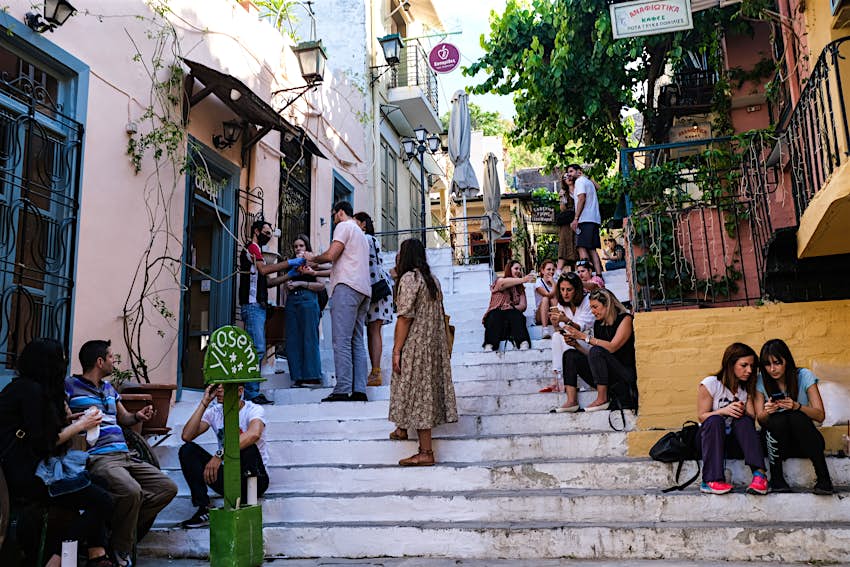 Tourists and locals mill about outside of a cafe opened for take away business in the Plaka district on May 23, 2020 in Athens, 