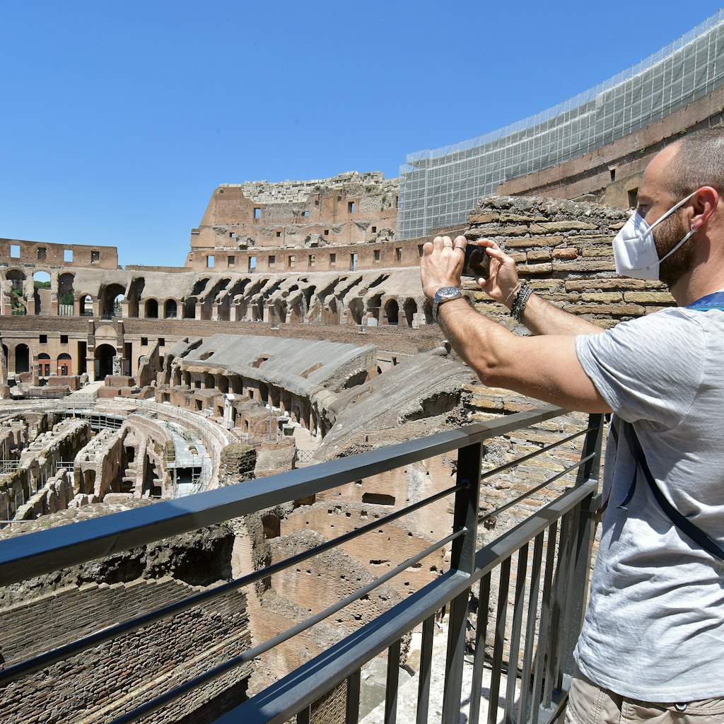 ROME, ITALY - JUNE 01:  People, wearing face masks, visit in the Colosseum, after three months of closure due to the COVID-19 lockdown measures on June 1, 2020 in Rome, Italy. The Parco archeologico del Colosseo and its monuments the Colosseum, Palatine, Roman Forum and Domus Aurea are opening to the public today, with access restrictions for visitors, as Italy relaxes Europe's strictest and longest-running coronavirus lockdown.  (Photo by Simona Granati - Corbis/Corbis via Getty Images)