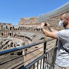 ROME, ITALY - JUNE 01:  People, wearing face masks, visit in the Colosseum, after three months of closure due to the COVID-19 lockdown measures on June 1, 2020 in Rome, Italy. The Parco archeologico del Colosseo and its monuments the Colosseum, Palatine, Roman Forum and Domus Aurea are opening to the public today, with access restrictions for visitors, as Italy relaxes Europe's strictest and longest-running coronavirus lockdown.  (Photo by Simona Granati - Corbis/Corbis via Getty Images)