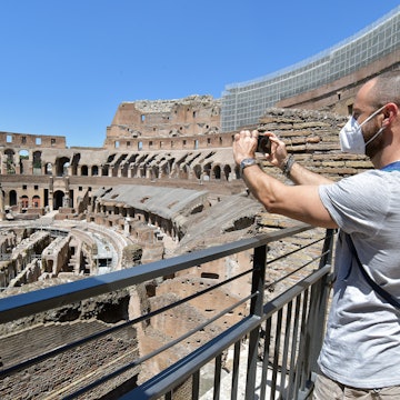 ROME, ITALY - JUNE 01: People, wearing face masks, visit in the Colosseum, after three months of closure due to the COVID-19 lockdown measures on June 1, 2020 in Rome, Italy. The Parco archeologico del Colosseo and its monuments the Colosseum, Palatine, Roman Forum and Domus Aurea are opening to the public today, with access restrictions for visitors, as Italy relaxes Europe's strictest and longest-running coronavirus lockdown. (Photo by Simona Granati - Corbis/Corbis via Getty Images)