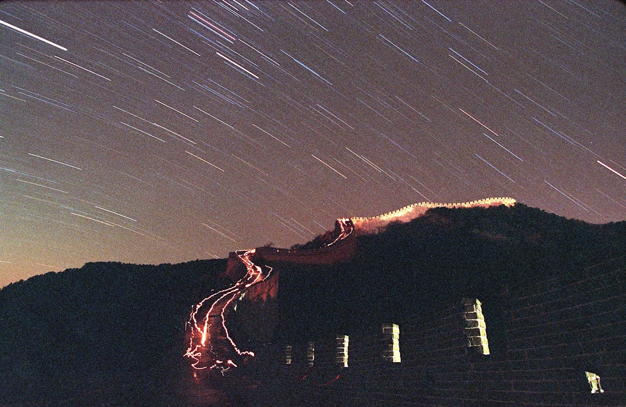 BADELING PASS, CHINA:  The Leonid meteor shower lights up the sky above China's Great Wall as stargazers brave the minus 20 degrees Celcius (minus 4 degrees Fahrenheit) temperature and walk up the wall with their flashlights 18 November in Badaling.      AFP PHOTO/Stephen SHAVER (Photo credit should read STEPHEN SHAVER/AFP via Getty Images)