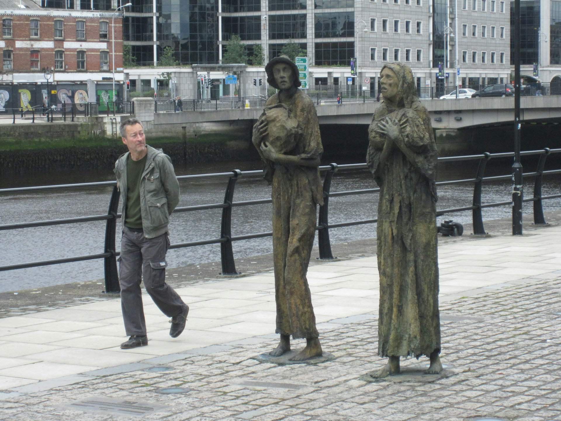 A man walks past a memorial to the Great Famine in Ireland - a sculpture of two emaciated women