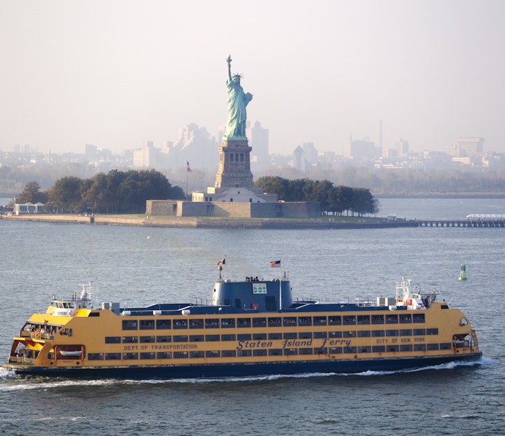 The Staten Island Ferry passes by the Statue of Liberty.