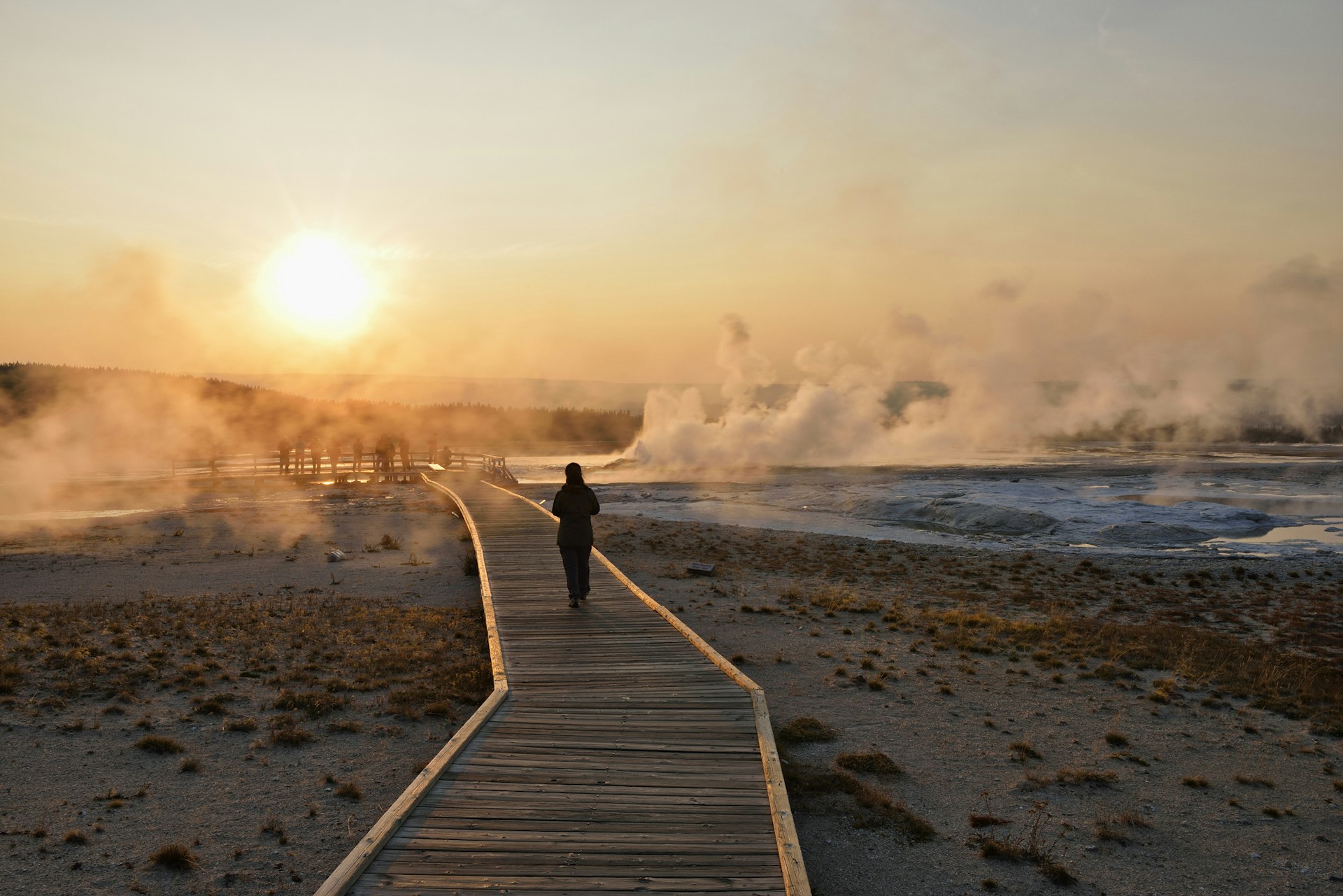 USA, Wyoming, Yellowstone National Park, woman walking on boardwalk at Lower Geyser Basin