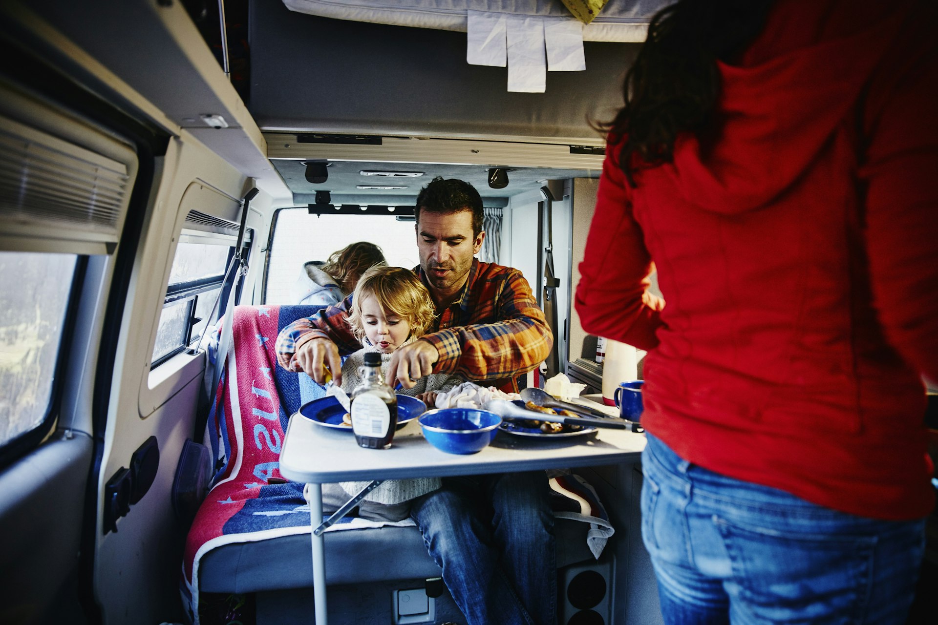 Family eating breakfast in camper van