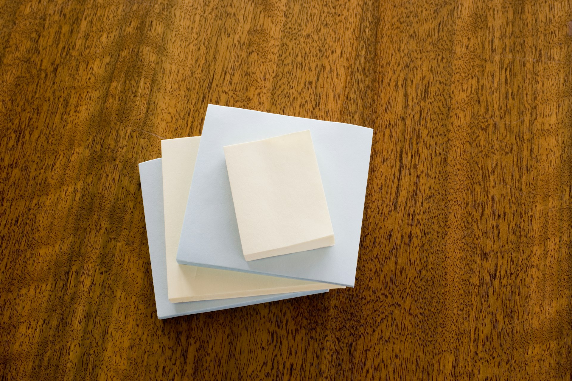 Stack of blank adhesive notes on a wooden desk