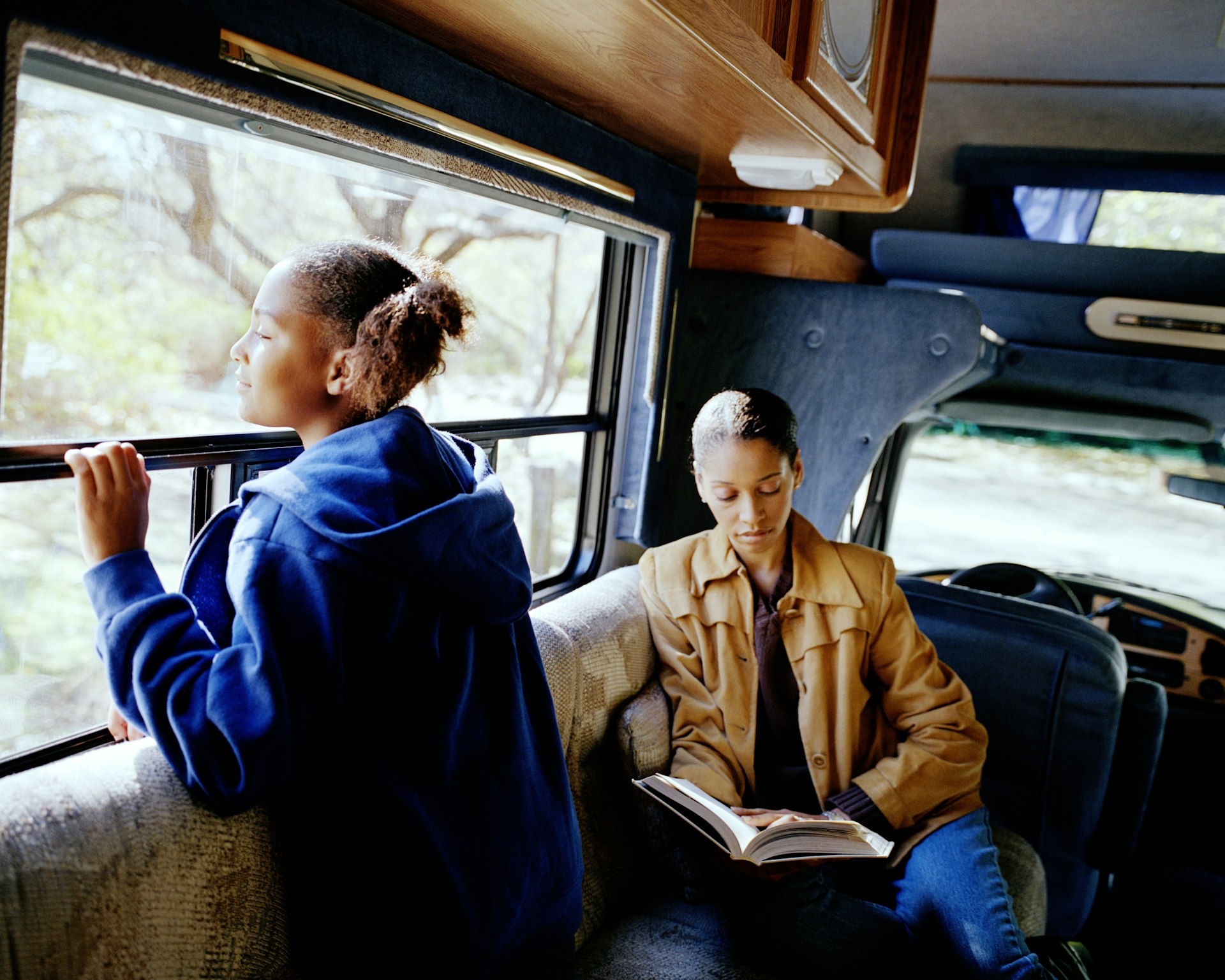 Mother and daughter (10-12) relaxing in camper van