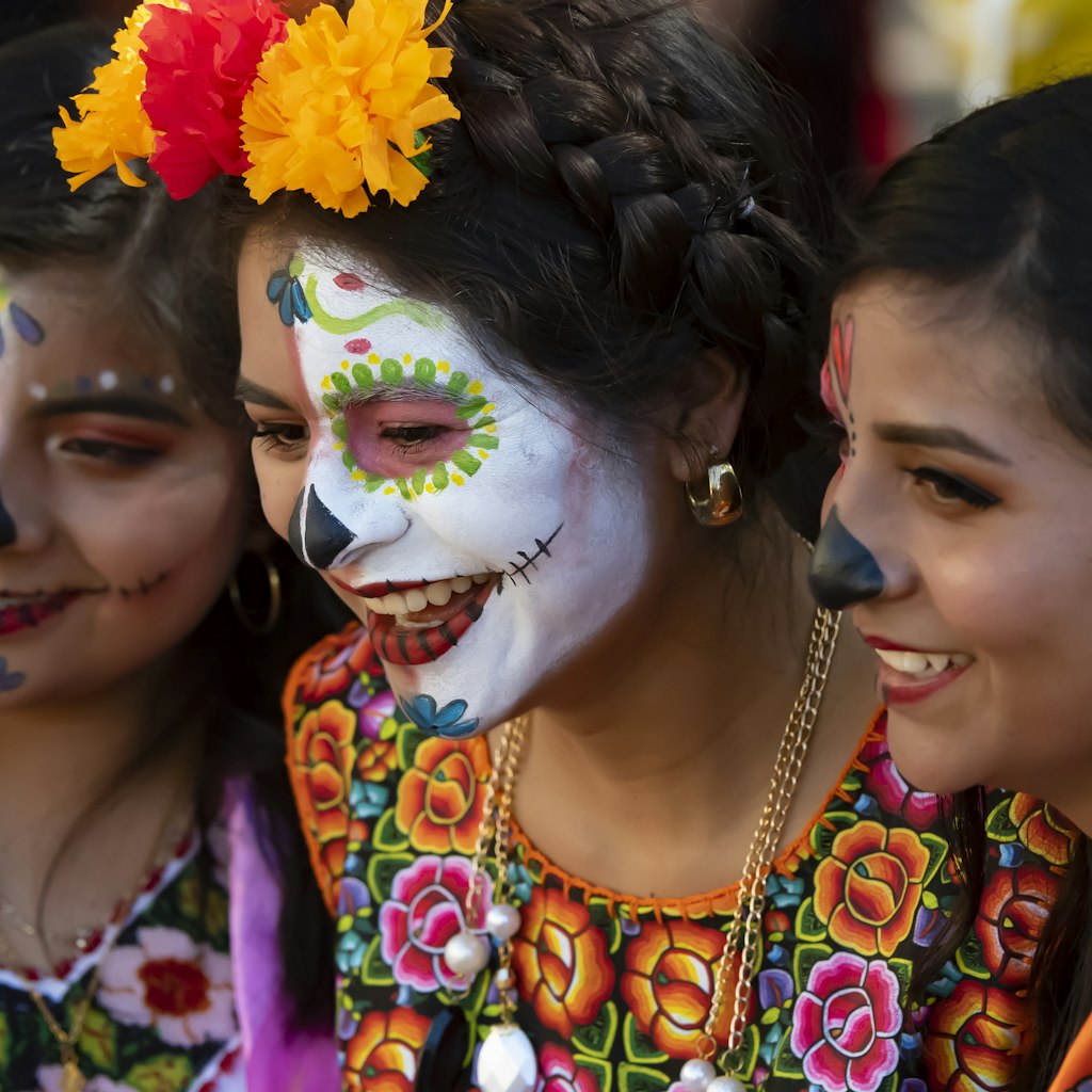 October 31, 2018: Three friends in costume and makeup in the zócalo (city square) for the Día de los Muertos festival.