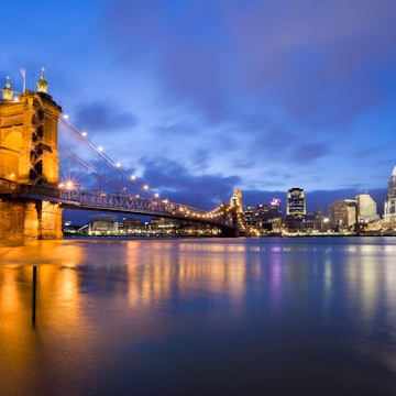 The Roebling Suspension Bridge and the Cincinnati skyline illuminated at night..