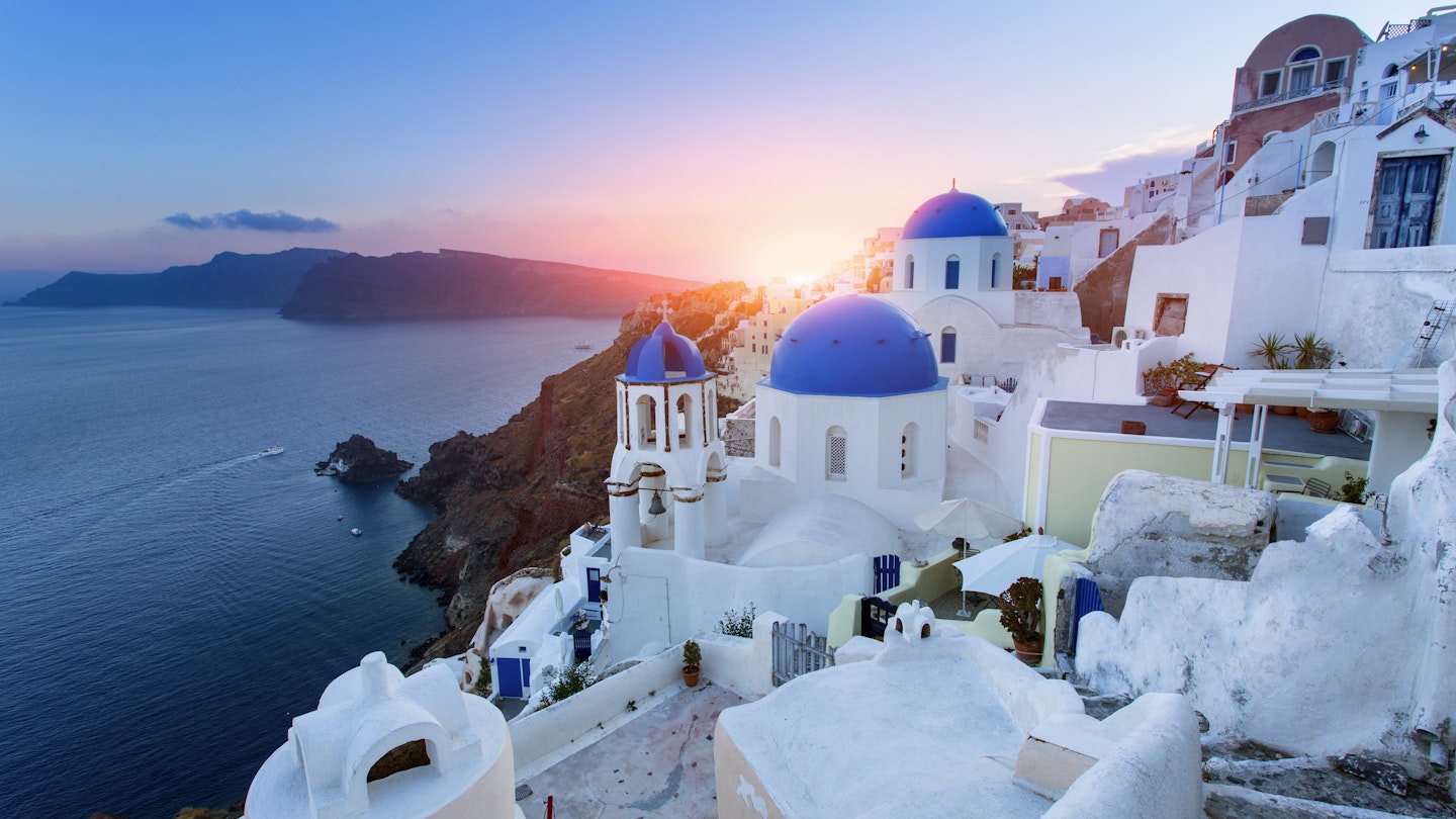 Blue domed churches during sunset in Oia.