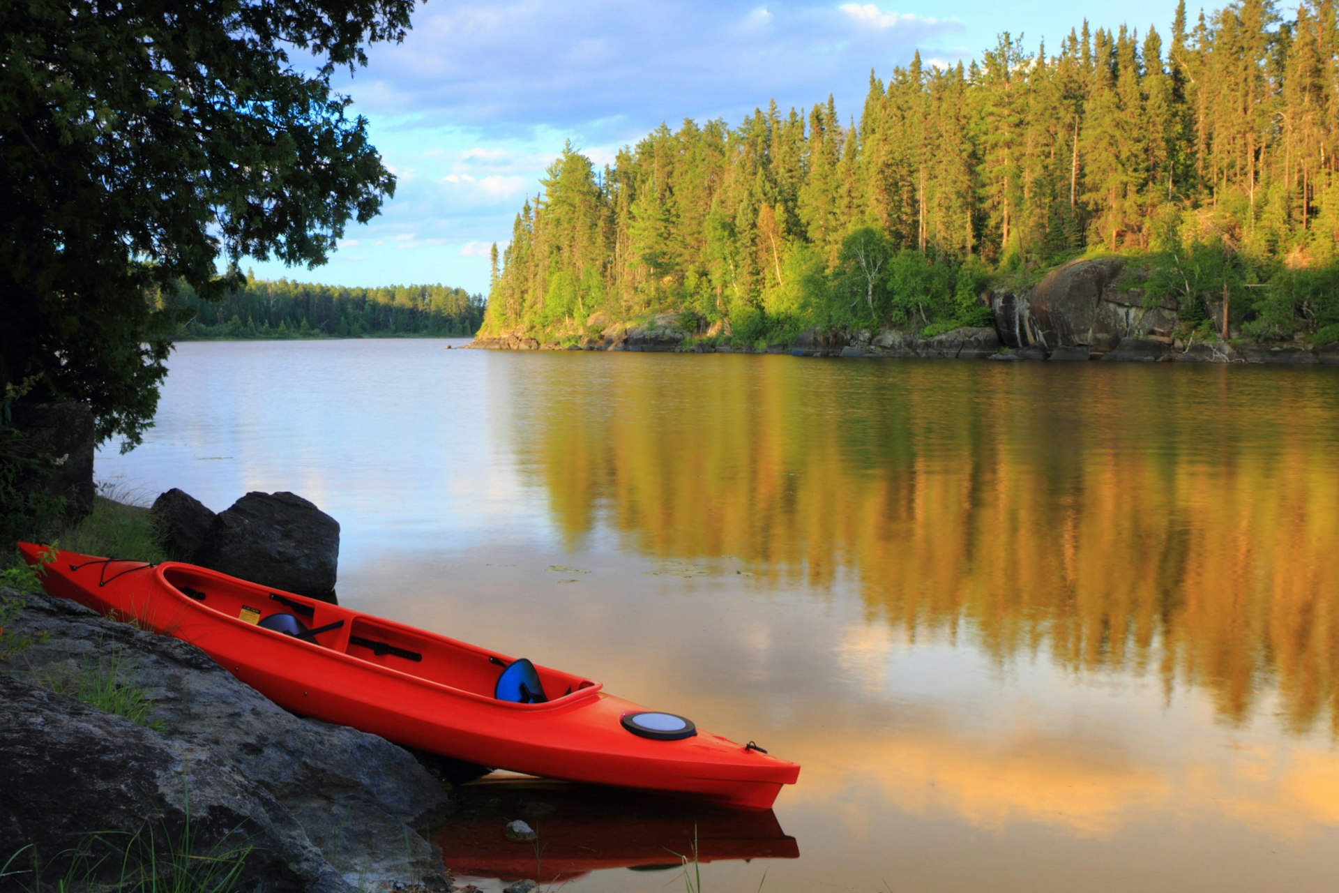A red and blue canoe at the lake on a sunny day