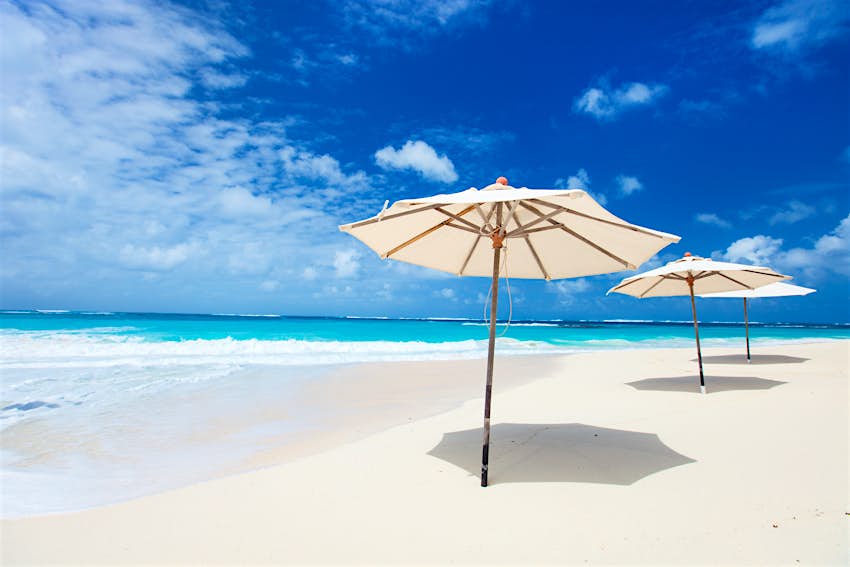 Umbrellas on tropical beach White umbrellas on a beautiful tropical beach at Anguilla, Caribbean