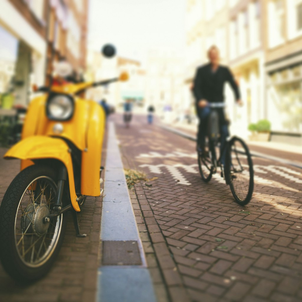 Street scene from Amsterdam downtown. Yellow scooter. Tilt shift lens.