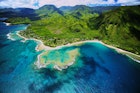 An aerial photo of Tunnels beach. Tunnels is located on Kauai's North Shore and is named after the tunnels that snorkelers and divers can observe when navigating the reef.