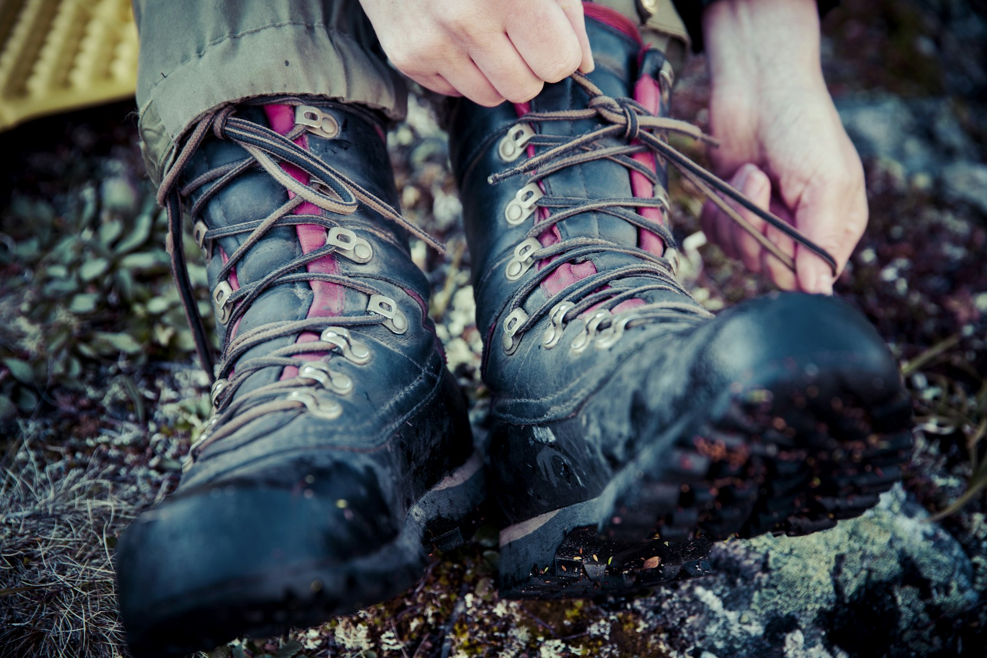 Low view of a hiker tying the laces of their hiking boots