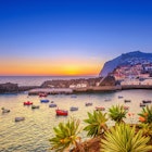 The beautiful fishing village of Camara de Lobos on the Portugese Island of Madeira at sunset; in the back the landmark Cabo Girao, the world second highest steep cliff (580 m).