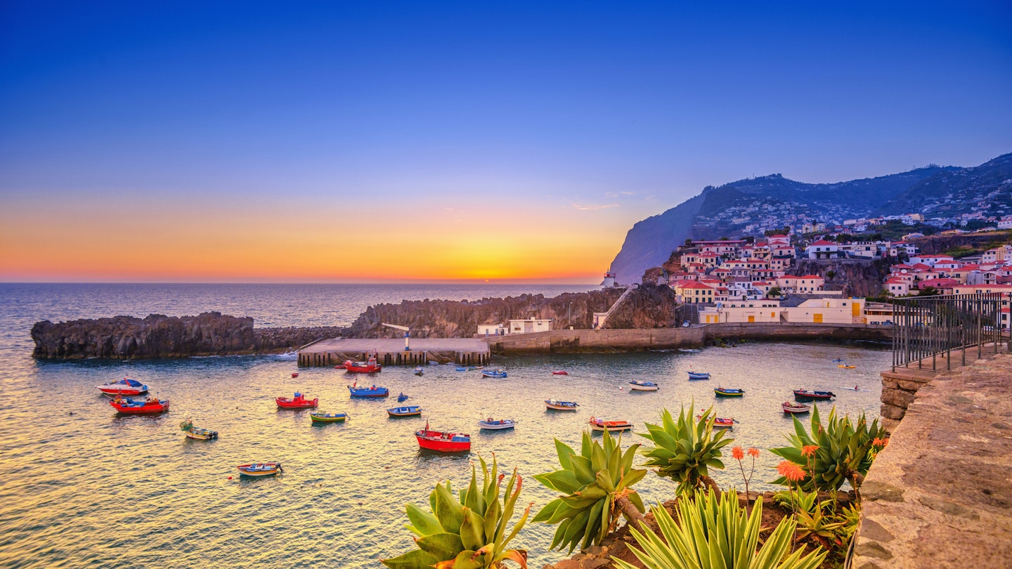 The beautiful fishing village of Camara de Lobos on the Portugese Island of Madeira at sunset; in the back the landmark Cabo Girao, the world second highest steep cliff (580 m).