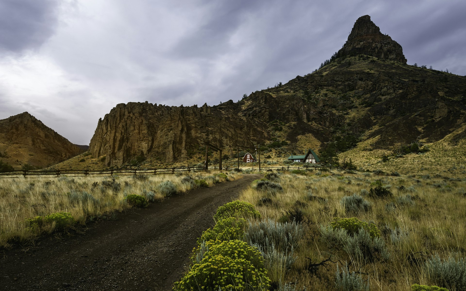 Homestead surrounded by rugged landscape, Cody, Wyoming, USA.