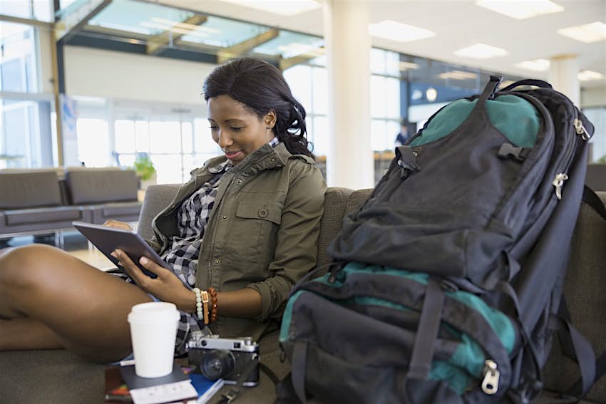 Woman with backpack and digital tablet in airport