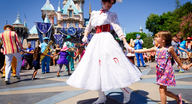 Anaheim, CA - August 10th 2016: Mary Poppins smiles at a young child as she leads a line of children in song and dance in front of Cinderella's castle during Disney's 60th Diamond Celebration.