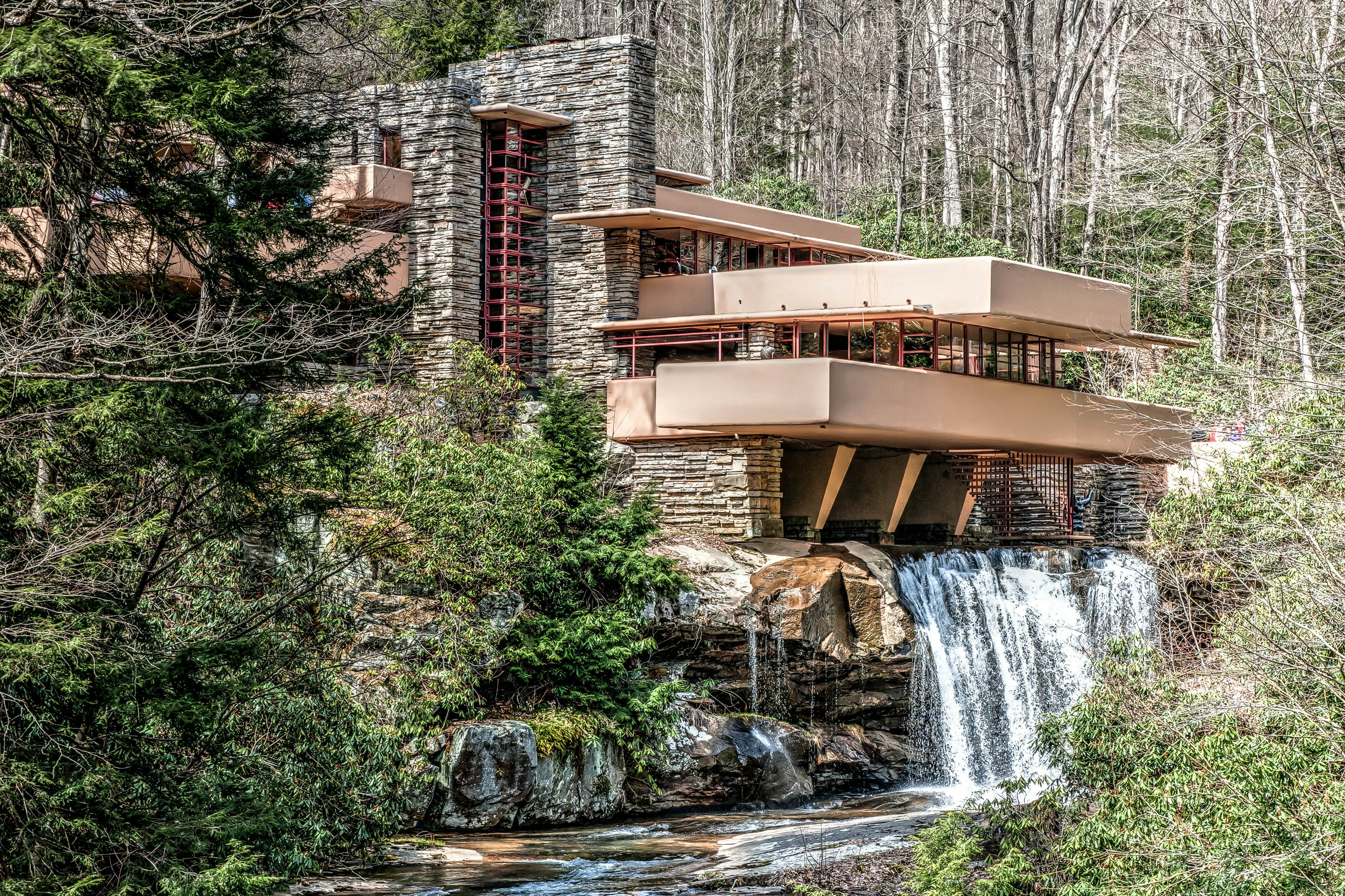 Mill Run, PA, United States - April 18, 2014: One of Frank Lloyd Wright's most famous works, Fallingwater was designed in 1935 and completed in 1937. Remarkable in that it seems to hover over a 30-foot waterfall, it is an example of Wright's organic design style. The house is well integrated with the environment, with gravity defying cantilevered balconies.