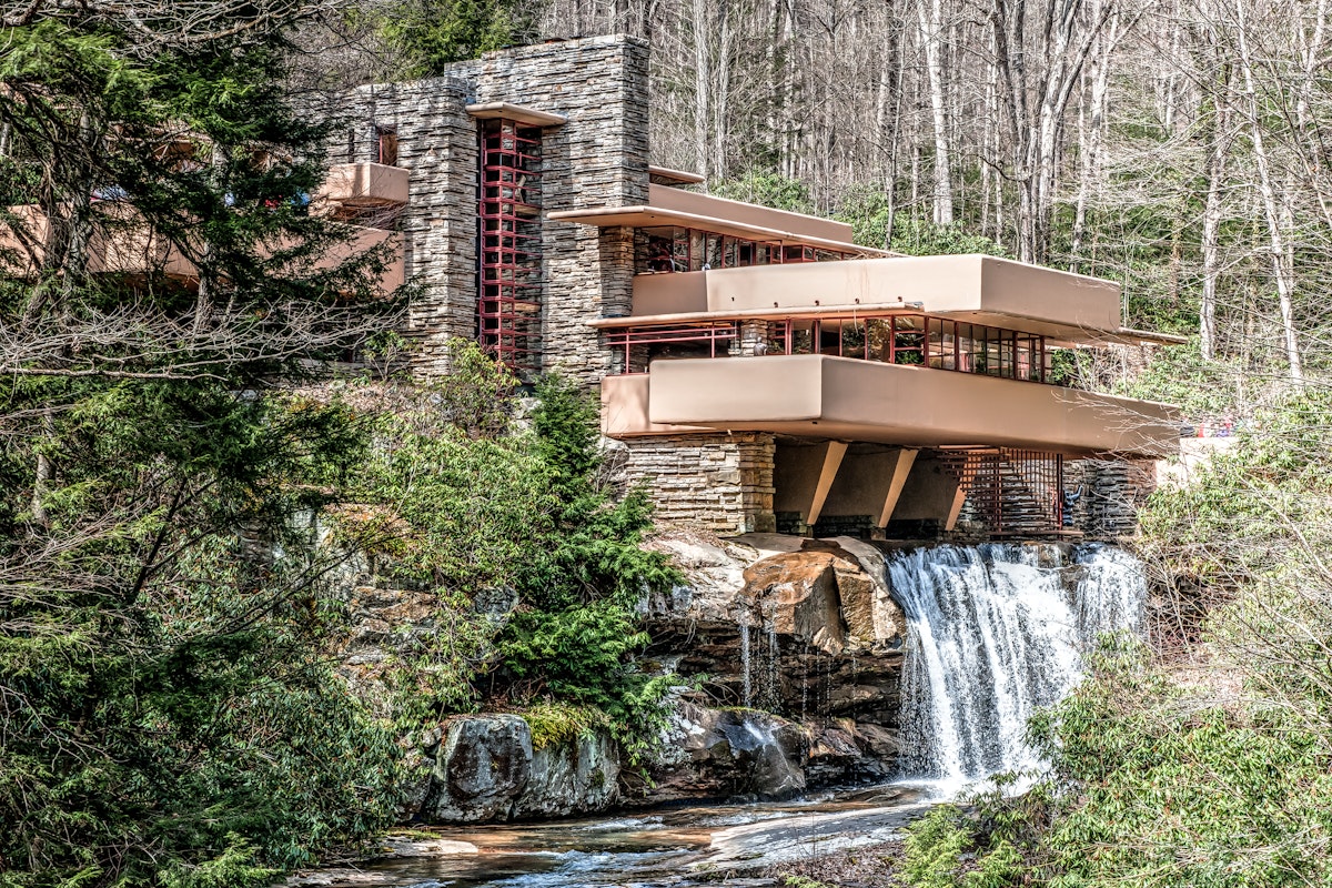 Mill Run, PA, United States - April 18, 2014: One of Frank Lloyd Wright's most famous works, Fallingwater was designed in 1935 and completed in 1937. Remarkable in that it seems to hover over a 30-foot waterfall, it is an example of Wright's organic design style. The house is well integrated with the environment, with gravity defying cantilevered balconies.