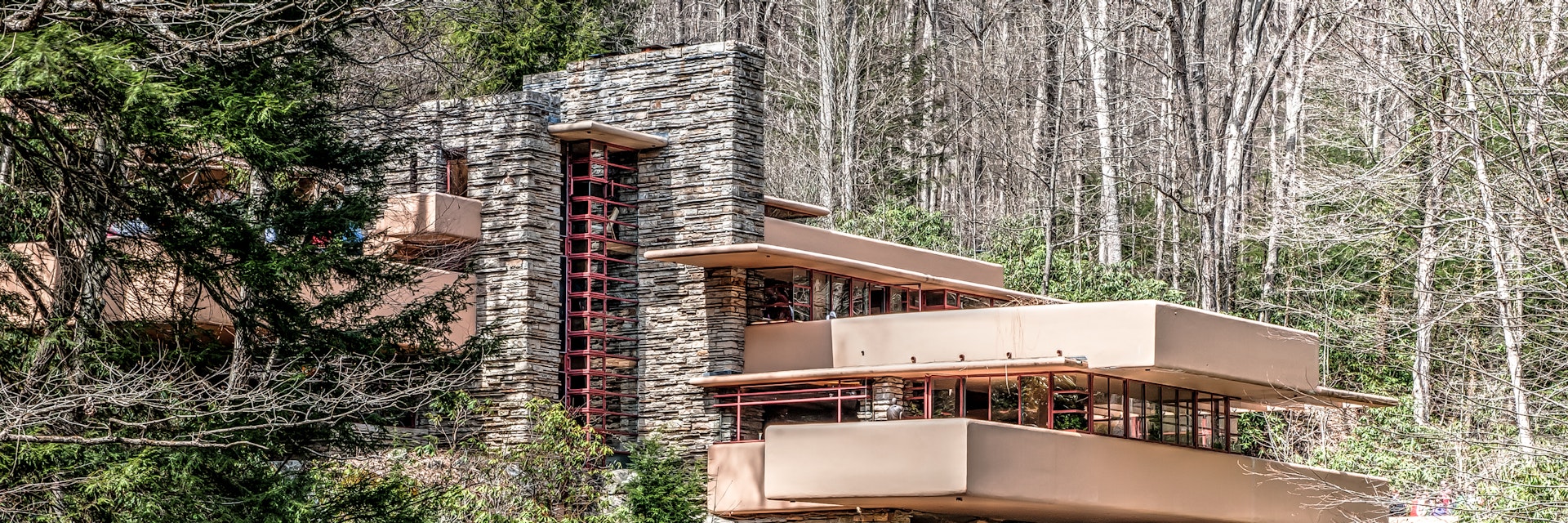 Mill Run, PA, United States - April 18, 2014: One of Frank Lloyd Wright's most famous works, Fallingwater was designed in 1935 and completed in 1937. Remarkable in that it seems to hover over a 30-foot waterfall, it is an example of Wright's organic design style. The house is well integrated with the environment, with gravity defying cantilevered balconies.