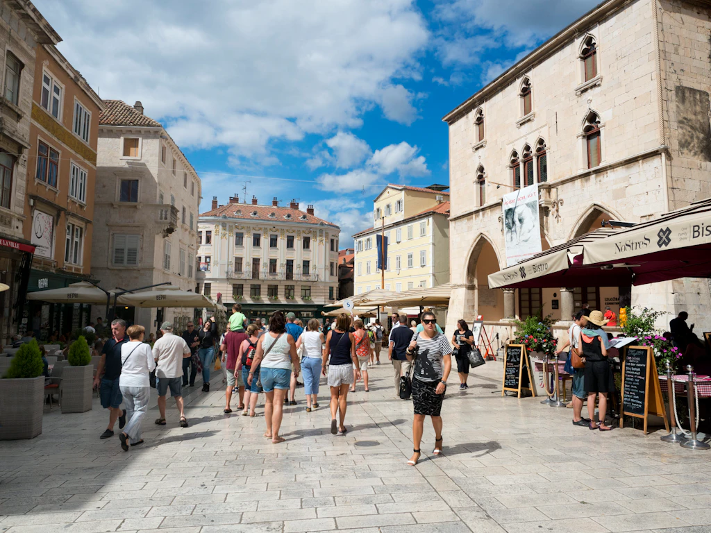 People walking through a square lined with restaurants and cafes