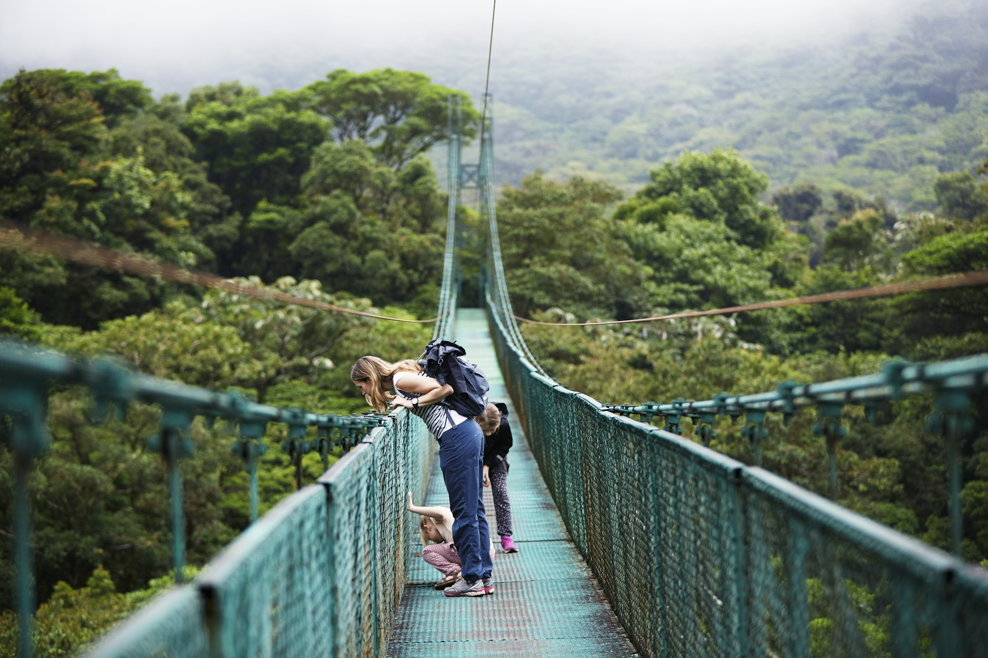 Mother with daughters on hanging bridge in Costa Rica. 