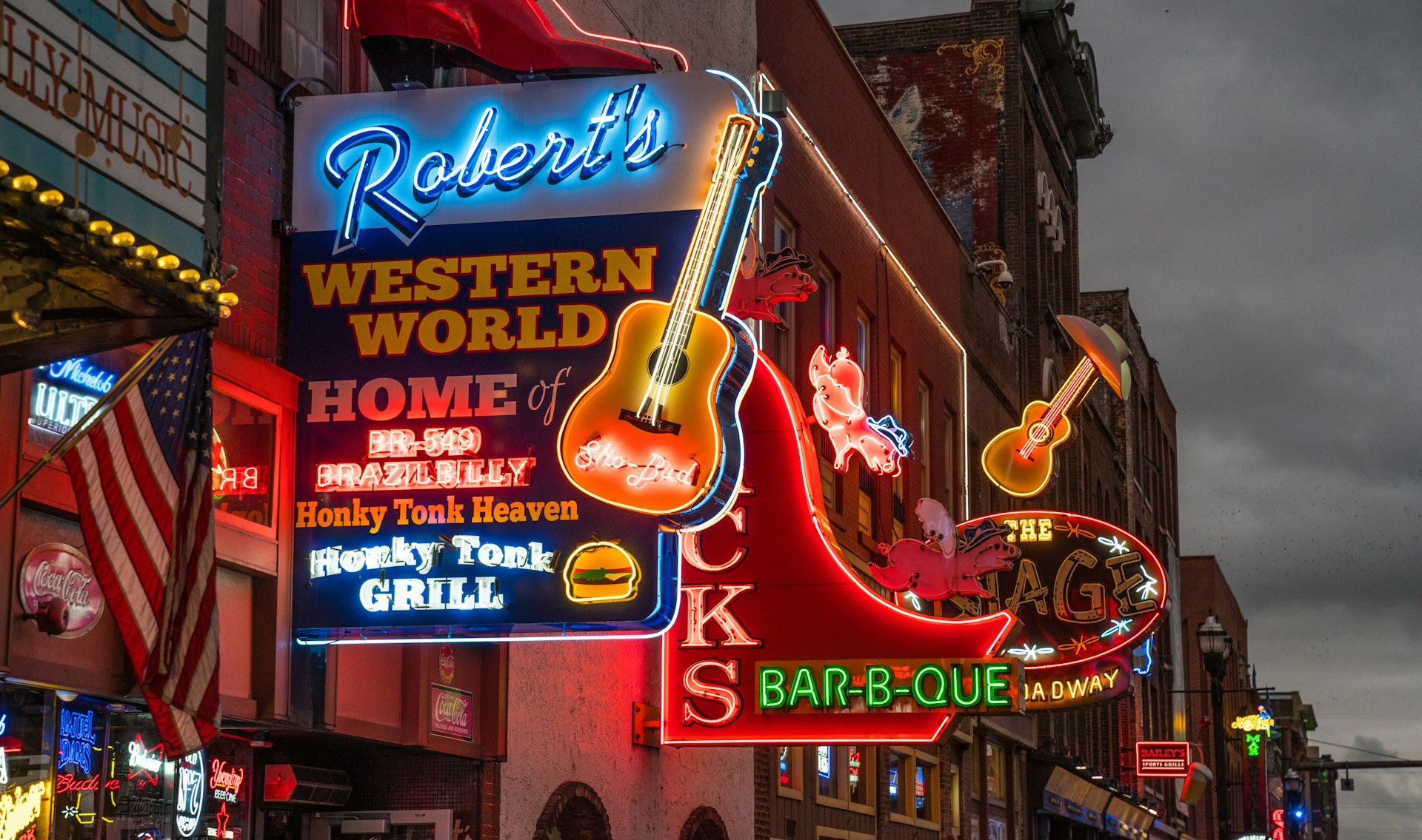 Neon signs outside bars and music joints on a street