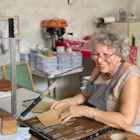 Mary, the mother-in-law of Ciclo's founder, making event programs from recycled paper