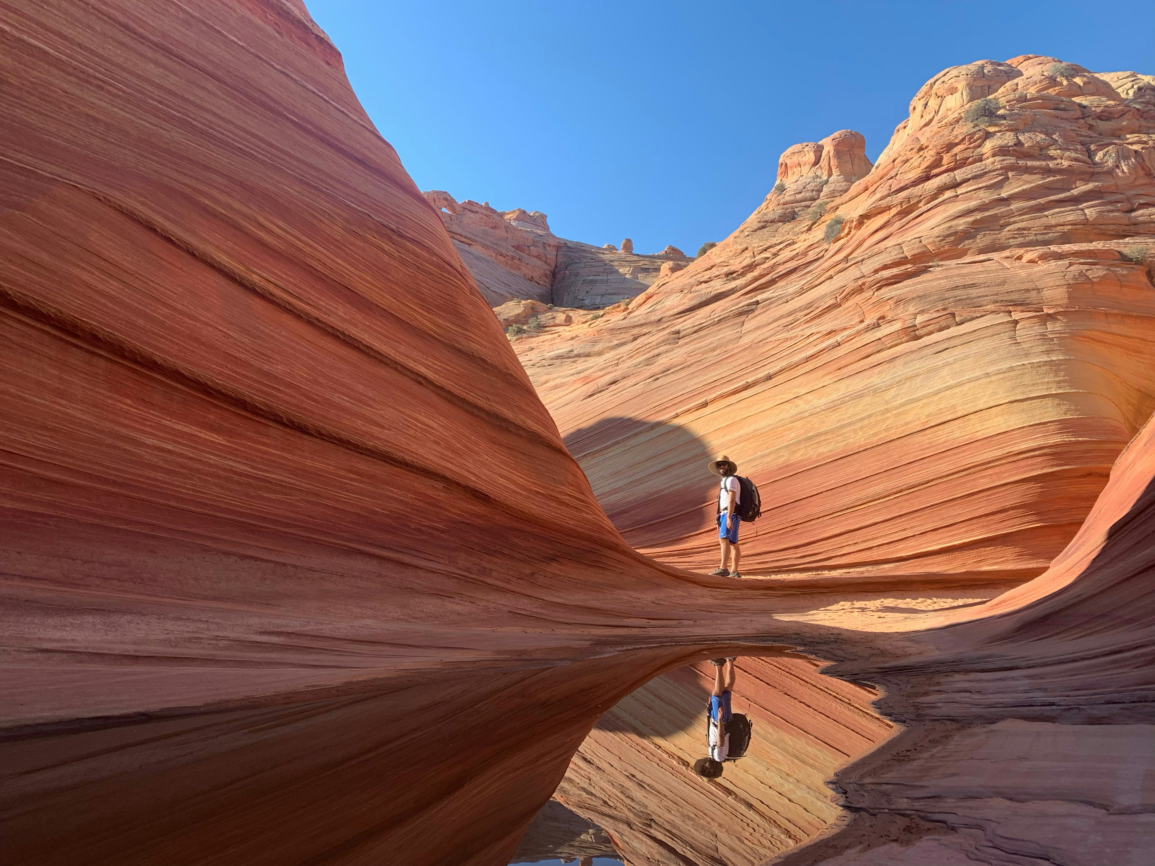 A person standing in a sandstone trough, with water pooled nearby