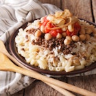 Arabic cuisine: kushari of rice, pasta, chickpeas and lentils close up on a plate on the table. horizontal.; Shutterstock ID 381168355; Your name (First / Last): Jack Palfrey; GL account no.: 65050; Netsuite department name: Online Editorial; Full Product or Project name including edition: LP.com Article - Travel kitchen