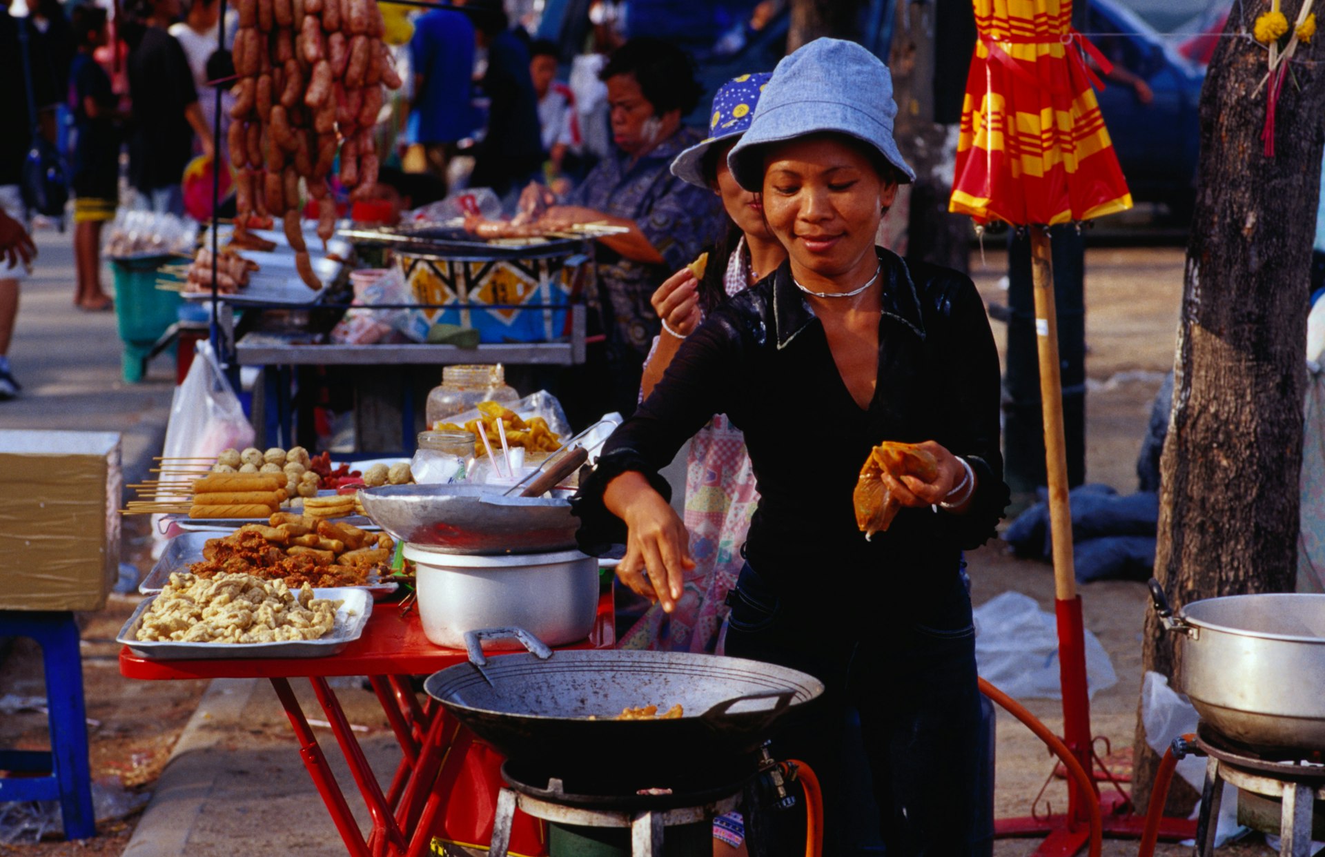Vendor cooking at her stall in Sanam Luang gardens in Ratanakosin