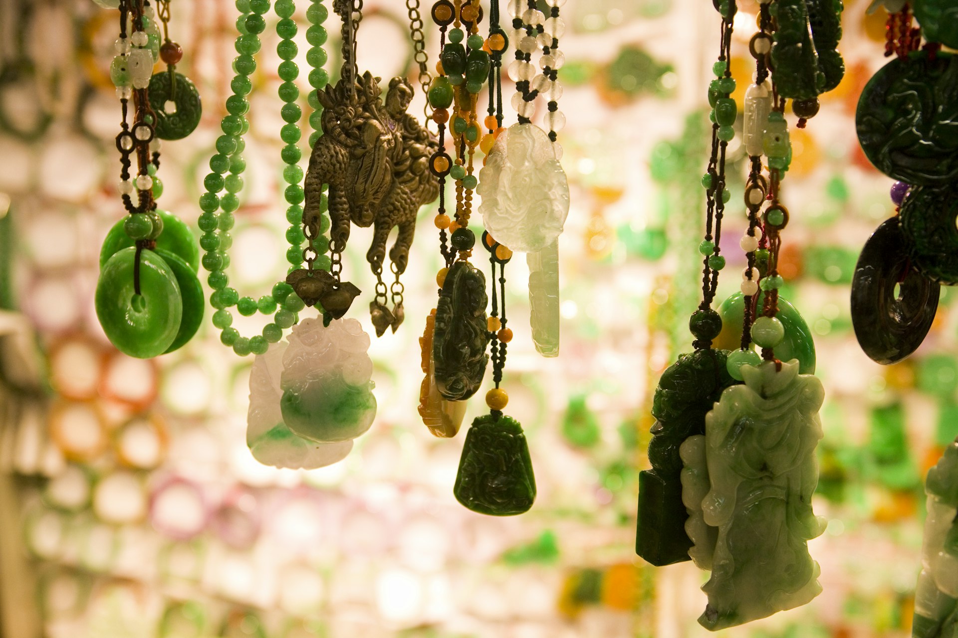 Close up of jade pendants hanging in a market stall.